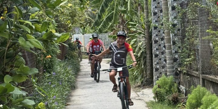 Thang leading group through village lane