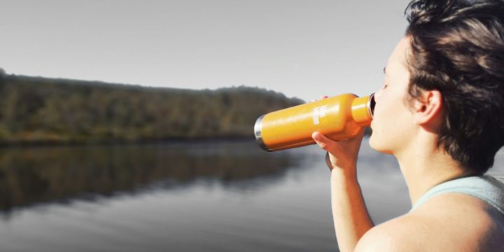 Woman drinking from open water bottle